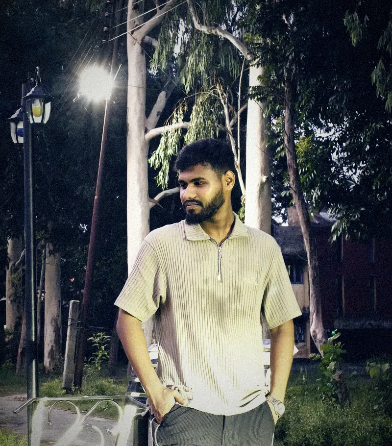 Anayet Hossain at night under a street lamp, graded like a film still